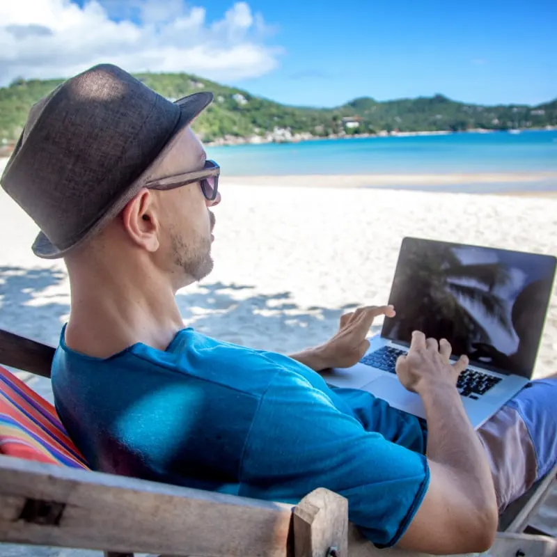 male digital nomad on the beach