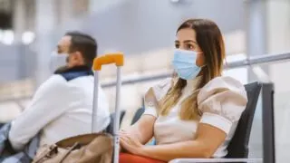 Young Female Tourist Wearing A Face Mask At The Airport
